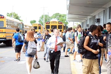 Mr. Brian Hoover makes his way through bus rider traffic after school to make students aware of changes in their bus schedules.