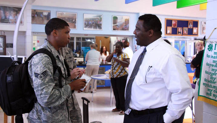 Principal Johnny Bush talks to a member of the military at a back-to-school event on MacDill Air Force Base.