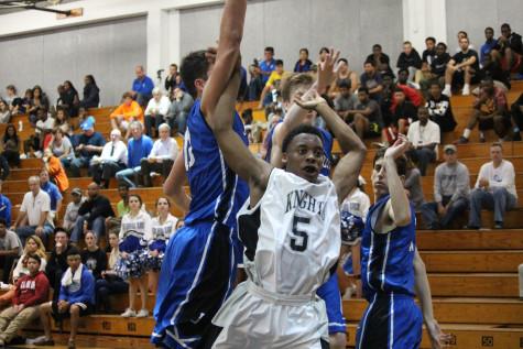 Iyan Mitchell ('15) blocks Jesuit's players. Mitchell lead the team with 14 points. 