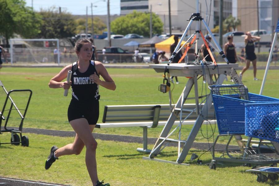 Going into her second lap, Raegan Giberson (17) runs the third leg of the 4x800m relay at Jefferson High School. Giberson ran the 4x800m relay and the 3200m run for the Knights.