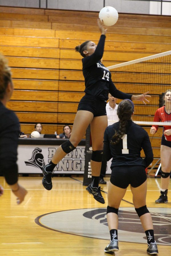 Captain McKenna Tyson (17) taps the ball over the net after a set by #1 Ashley Osiason (18).