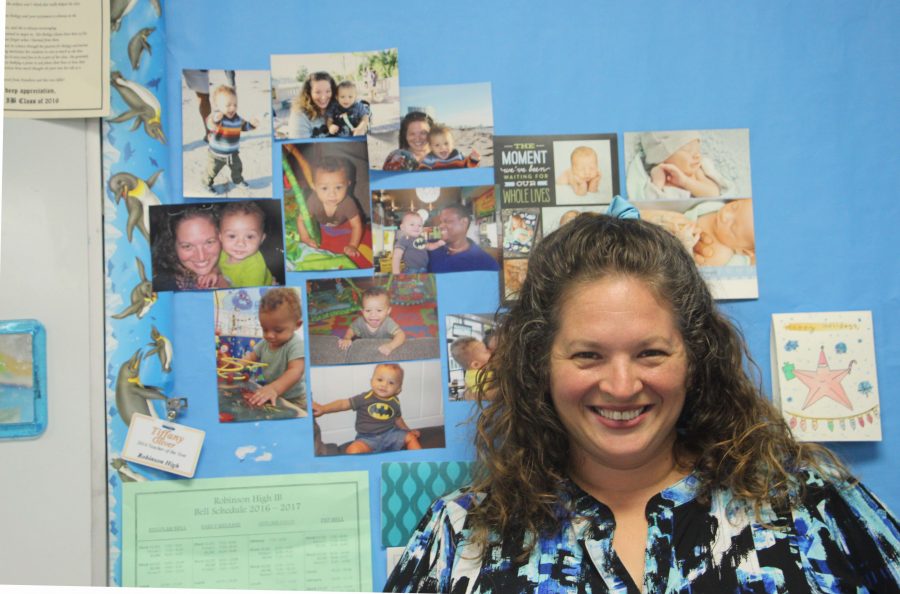 Biology teacher stands near a board with photos of her son, Mason.