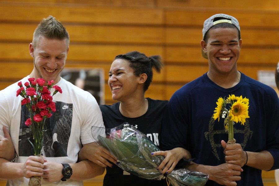 With brothers Thomas (left) and Malik (right) escorting her, McKenna Tyson (17) walks down the court during senior night celebrations before Robinsons game against Durant. 