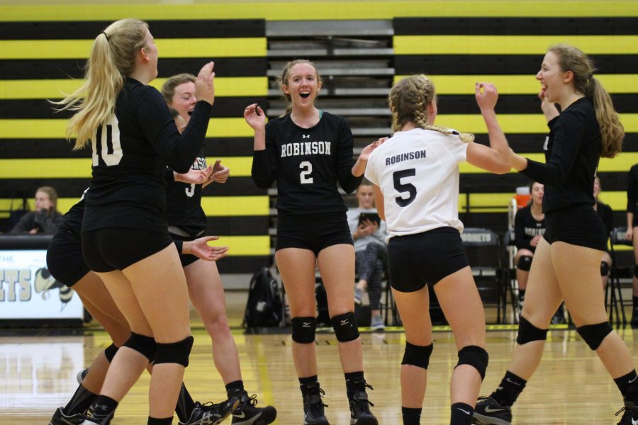 The team celebrates after scoring a point in the second set.