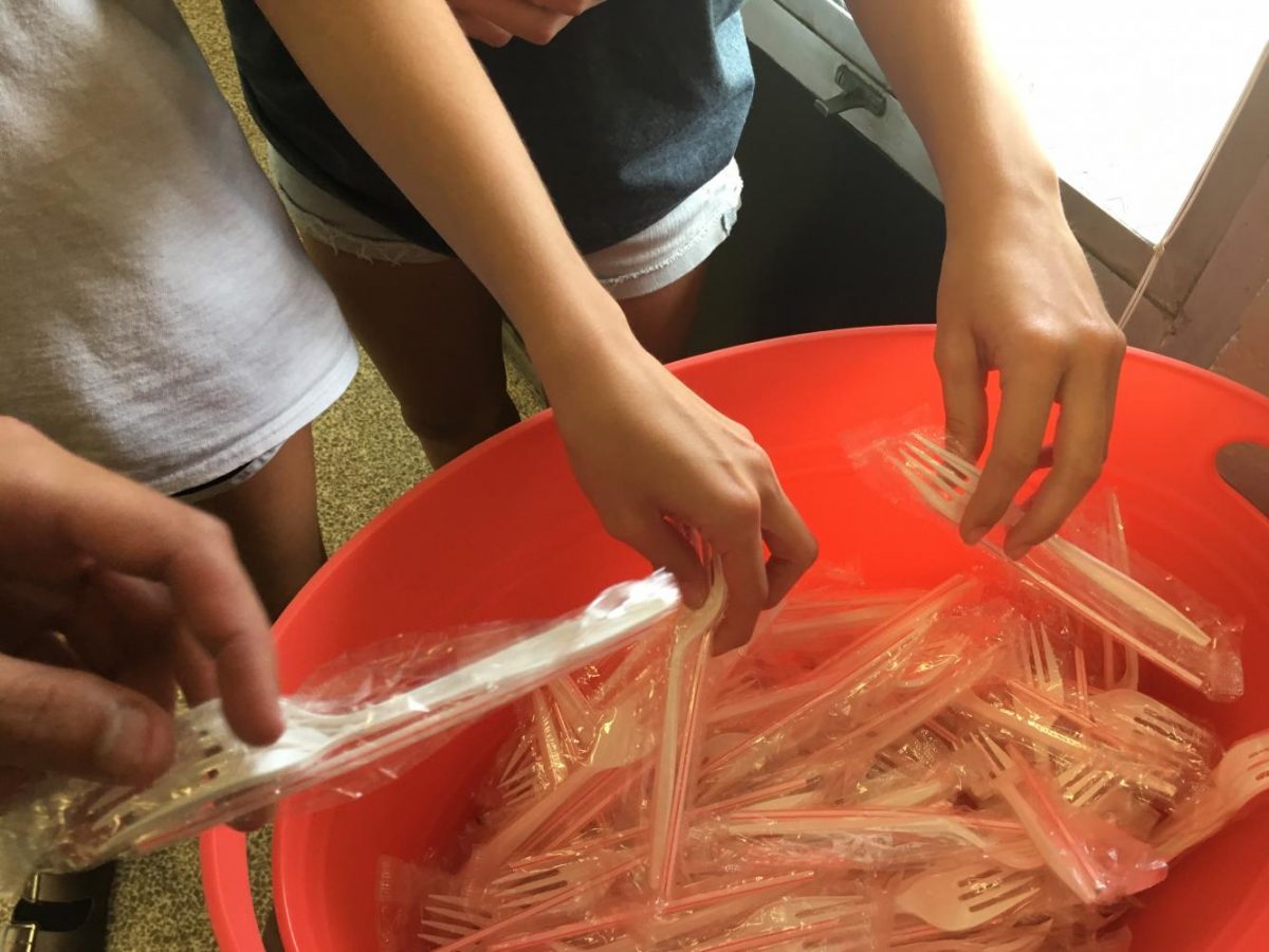 Students grab a fork and straw at lunch. These plastic packages are the only way to get a fork or straw from the lunchroom.