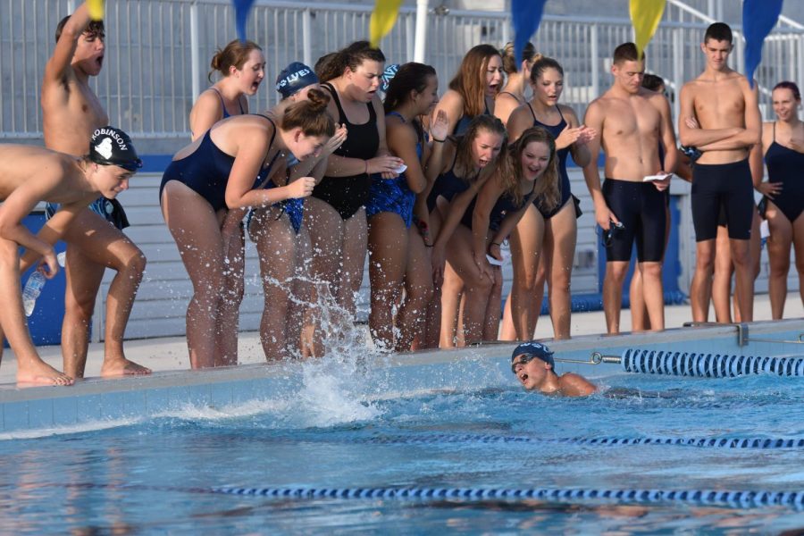 The swim team cheers on a swimmer at a recent swim meet.