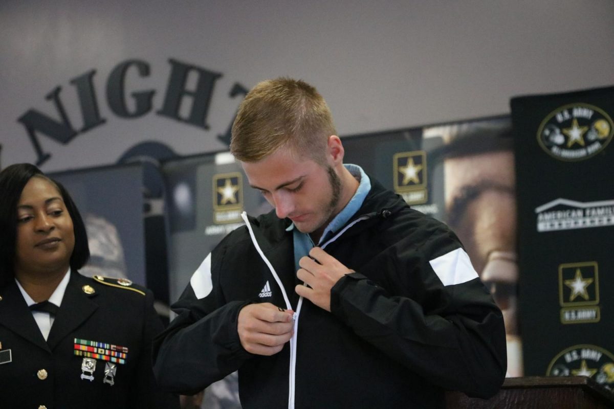 Marching Knights drum major Bryce Buckland (18) zips up his jacket as part of his initiation into the U.S Army All American Marching Band.