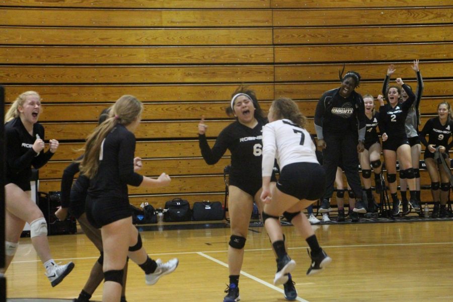 The Lady Knights cheer after Kristin Werdine (19) attacks the ball for a kill in the third set.