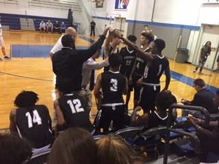 The 2017-18 boys basketball team breaks out of a huddle in their game against Jesuit.