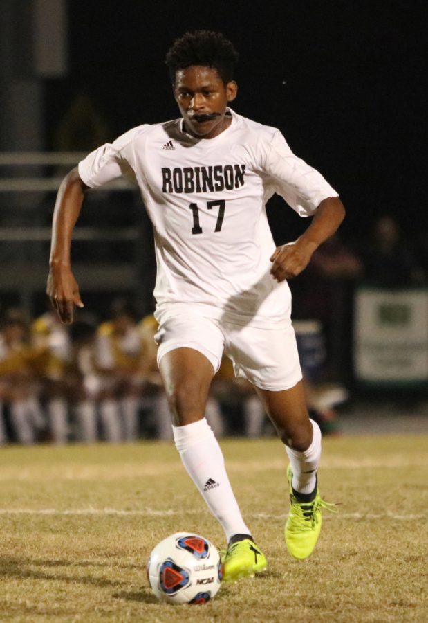 Senior Solomon Browne dribbles the ball up field in their game against Plant on Jan. 16.