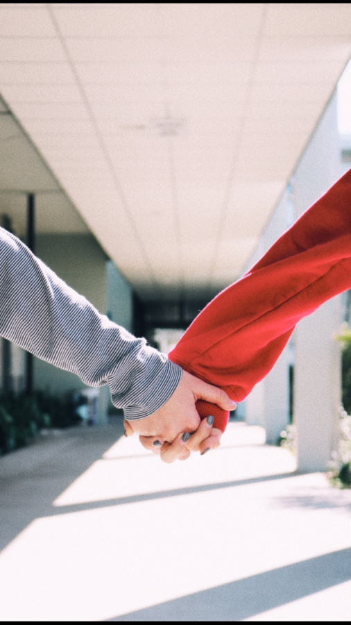 A student couple holds hands in the halls of Robinson.