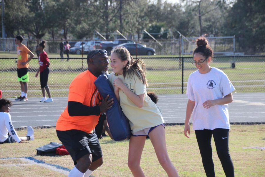 Sadie Jacobson (21) runs into Earnest Byner during a drill at flag football conditioning. 