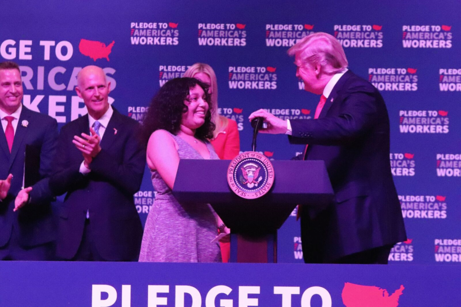 While shaking hands with Isabella Cruz, President Donald Trump introduces the upcoming senior to talk about her success at Tampa Bay Tech.