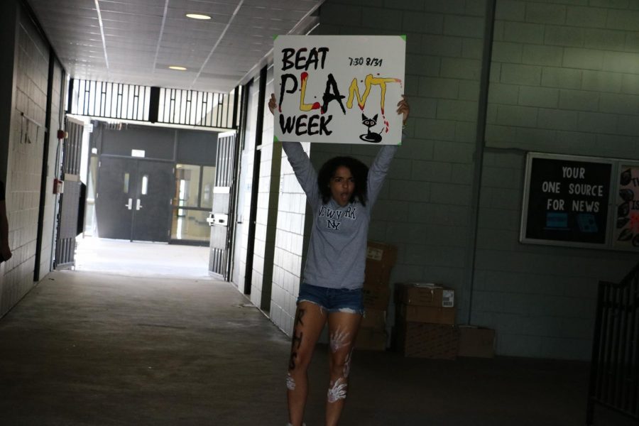 Natalia McCallaa (20)  gets students pumped up for the pep rally in the hallway