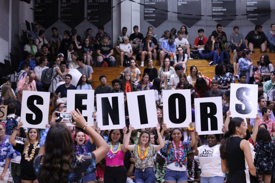 Several students hold up signs to indicate the senior section during the pep rally and show their spirit.