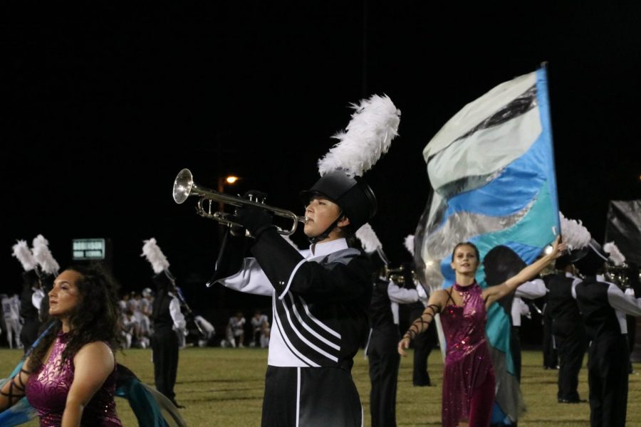 Emma Barrett (21) performs her trumpet solo at the varsity football game vs. Jesuit on Oct. 11.