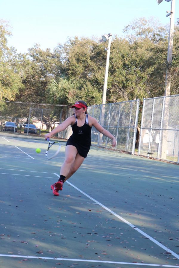Alivia Teplin (20) runs to the back of the court to keep the tennis ball from flying out of bounds.