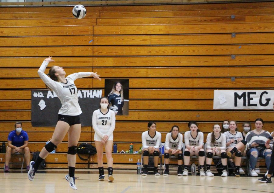 Mila Yarich (21) serves the ball as her teammates watch nearby. Yarich, one of the teams captains, has committed to play volleyball at Yale University.