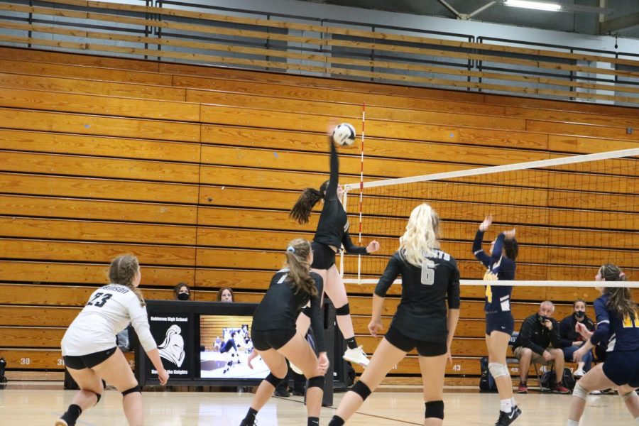 Maddie Hill (22) spikes the ball to the opposing team.