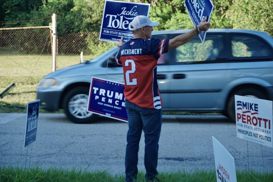 A man holds sign displaying his support for local candidate Jackie Toledo.