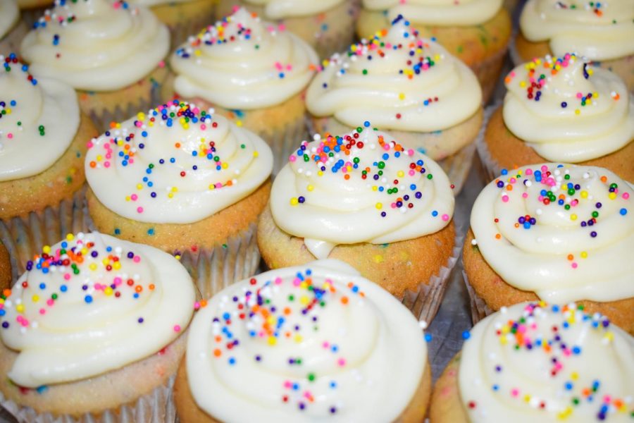 Confetti cupcakes decorated with cream cheese frosting and rainbow sprinkles.