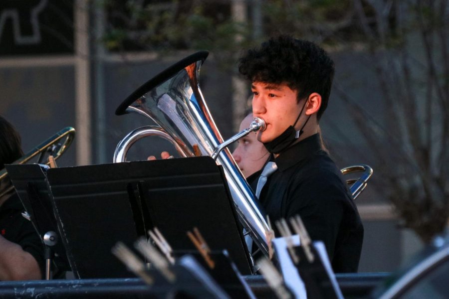 The sun hits Cole Riggs (23) face as he plays his euphonium.