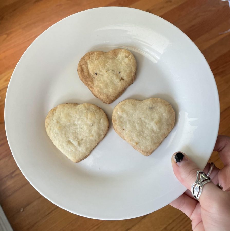 Heart-shaped lavender shortbread cookies with golden brown edges, arranged on a plate. 