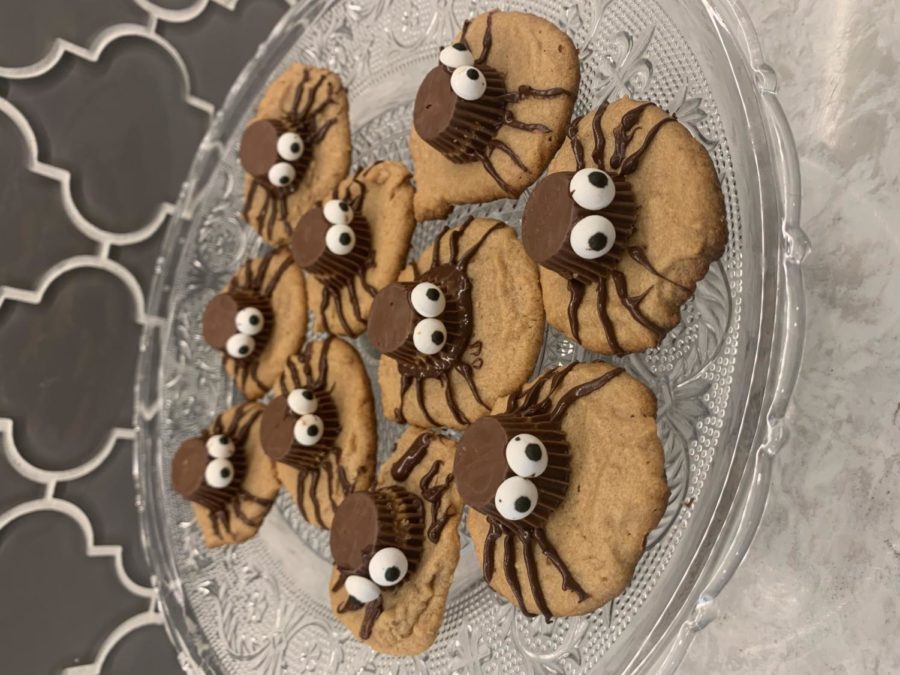 The peanut butter spider cookies are placed on a platter to cool. They are made just hours before a Halloween party, and they look delectable.   