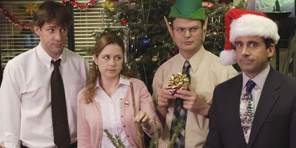 Jim, Pam, Dwight and Michael from the show The Office all stand around each other other during a Christmas Party.