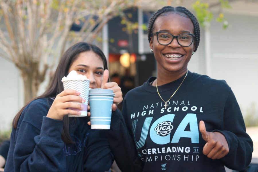 Julianna Lebron (23)(left) and Sara Gainer (23) pose with their hot chocolates outside on the patio during lunch.