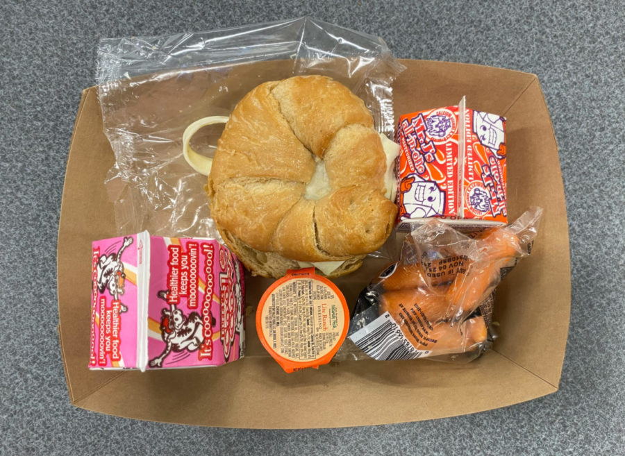 The school lunch on November 5th, 2021 contains a breakfast  sandwich, a drink, and carrots. You can pick also pick a drink as one of your side items as shown by the two drinks in the photo.