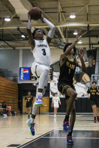 Myron Thomas (‘23) jumping up to make a basket while an opposing player attempts to block him. Robinsons varsity boys basketball team welcomed a lot of rookies this year and the team has been working on teamwork. We just [have to] jive together. The team needs to jive and were good, Thomas said.