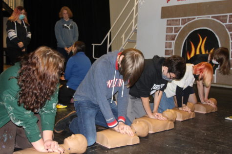 A group of Robinson juniors attempts to perform CPR on mannequin.