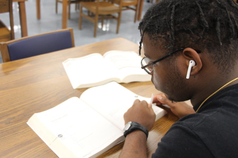 A student looks over one of the provided SAT practice books in the RHS media center. 