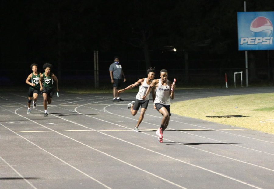 Justin Richardson (23) hands off the baton to Joshua Walker (22) in the 4x100 meter relay. The team won first place, making a great victory for Josh Walker and Juluan Johnson. 
