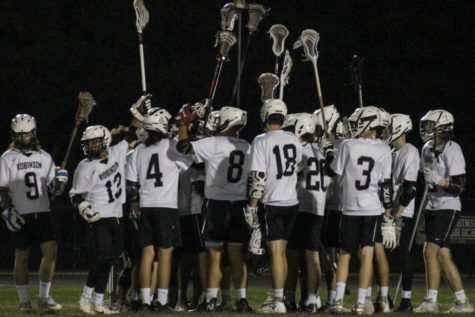 The boys lacrosse team toss the crosses in the air to celebrate their win on Senior Night on March 30th.