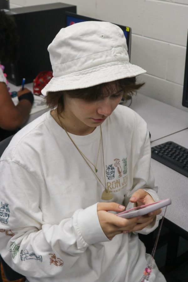 Grace Hilton (24) using her phone during class.