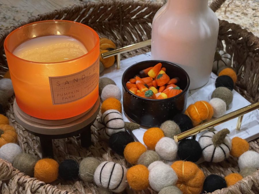 Fall decorations with a candle and bowl of candy corn.