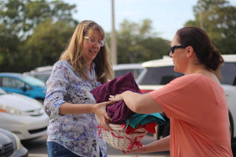 Kimberly Meguiare the new PTSA President taking donations from parents for annual dress drive.