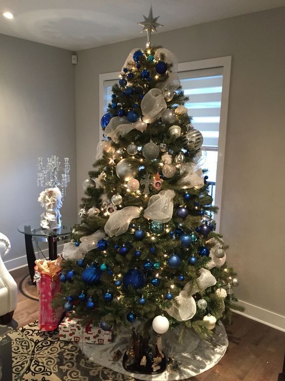 An artificial Christmas tree decorated in frosty blue and white decorations.