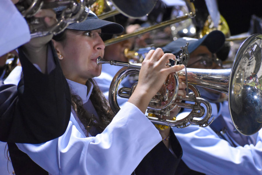Grace Barrett (23) plays her horn in the stands during football games. 