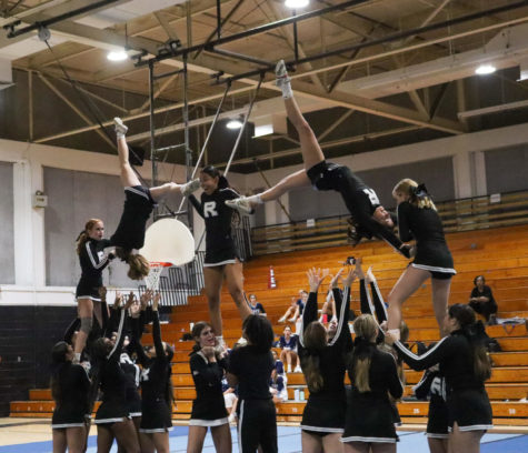 The cheerleading team preforming a group stunt at the first competition of the season.