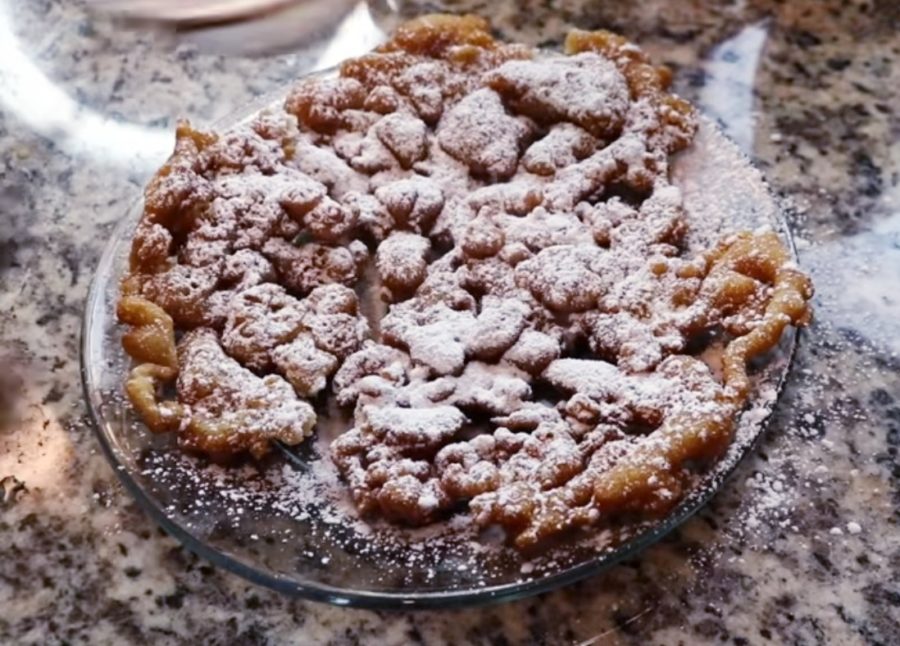 Homemade funnel cake topped with powder sugar.