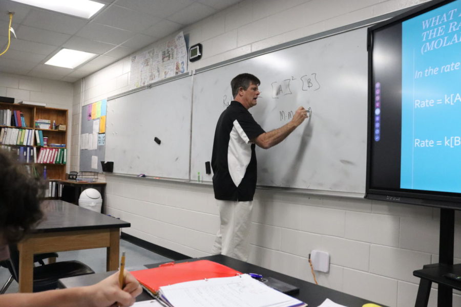Robinson Chemistry teacher James Atkins writes chemistry stuff on his white board during a junior IB Chemistry class.