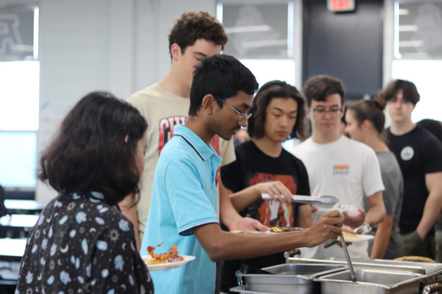 Praveen Prabaharn (23), the IB Salutatorian, scoops up some hot breakfast. The arrangement was prepared by Robinson culinary students for the top 10 highest ranking GPA students for IB and Traditional. 