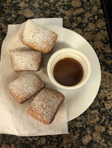 Warm homemade Beignets topped with powder sugar and paired with caramel sauce.