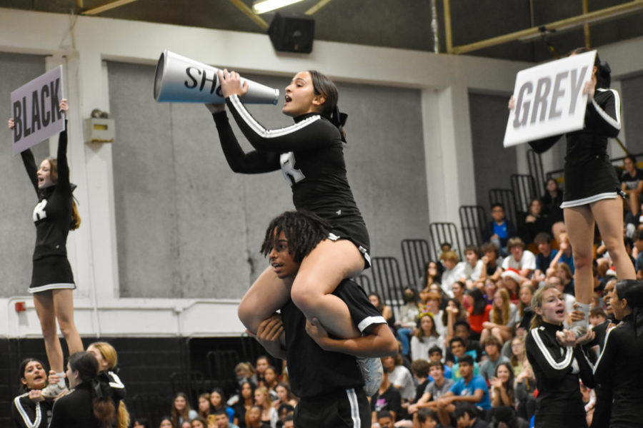 Kameron Padgett (24) carries Sela Teplin (23) during the competition cheer teams pep rally routine at the winter sports pep rally.