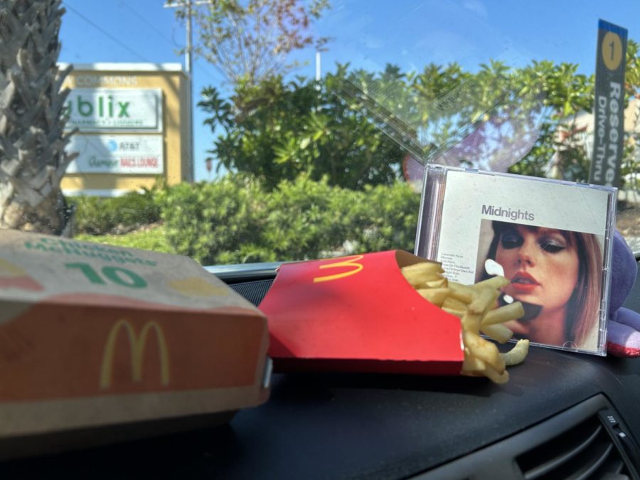 The Target exclusive CD of Taylor Swift's "Midnights" album next to a McDonald's 10-piece Chicken McNugget box and fries.