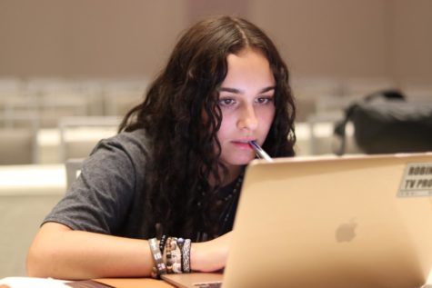 Makayla Canino (23) focus at the computer screen as she works on the 2023 yearbook at Camp Orlando last summer. 