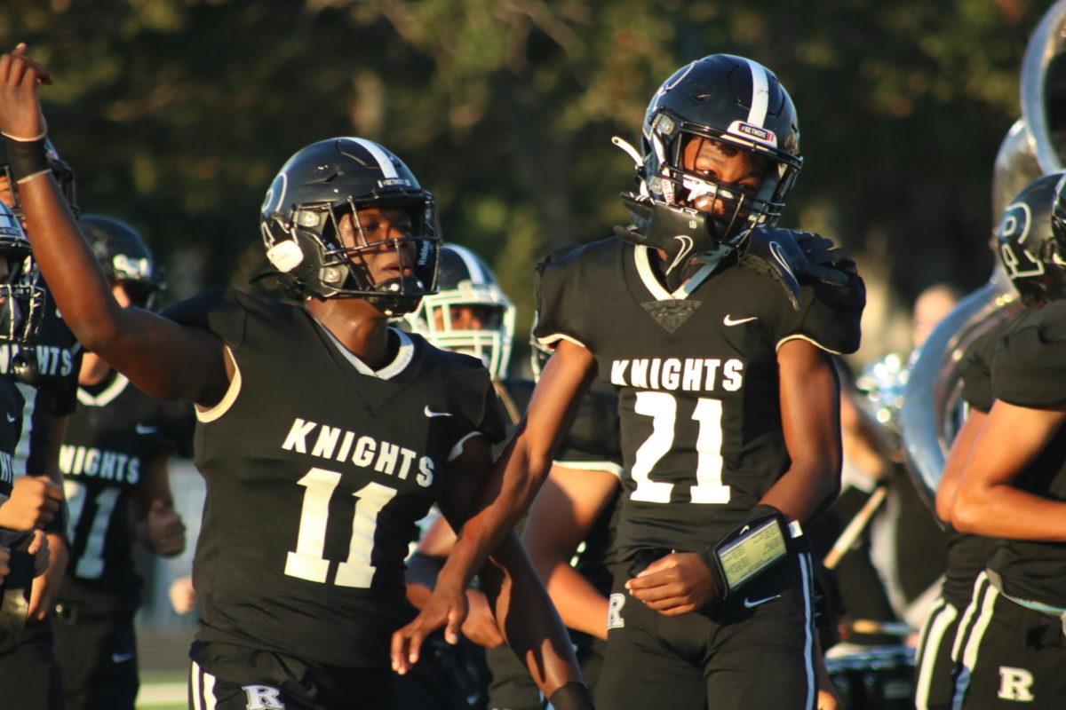 LAJessie Harold ('25) (left) and Tyrone Carlton ('27) (right) running out to the field right before the game starts.